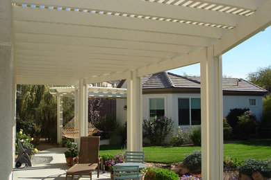 Modelo de patio clásico en patio trasero con pérgola y losas de hormigón