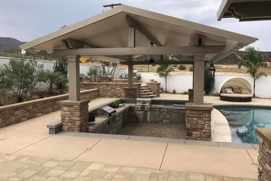 Inspiration for a mid-sized transitional backyard concrete paver patio kitchen remodel in Los Angeles with a gazebo