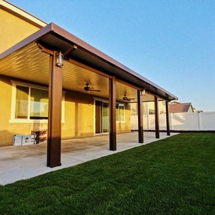 Immagine di un grande patio o portico chic dietro casa con lastre di cemento e un gazebo o capanno