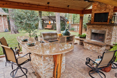 Example of a large transitional backyard gravel patio kitchen design in Houston with no cover