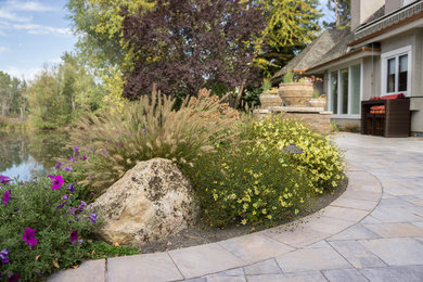 Inspiration for a large timeless backyard stone patio remodel in Boise with no cover