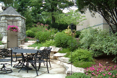 Patio - mid-sized traditional backyard stone patio idea in Columbus with no cover