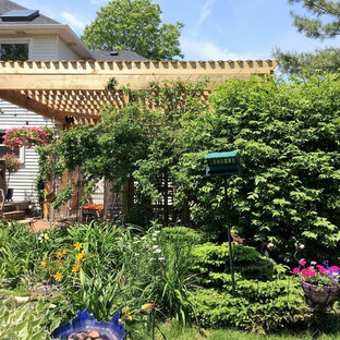 Ispirazione per un patio o portico stile americano di medie dimensioni e dietro casa con pavimentazioni in pietra naturale e una pergola