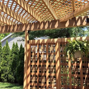Immagine di un patio o portico stile americano di medie dimensioni e dietro casa con pavimentazioni in pietra naturale e una pergola
