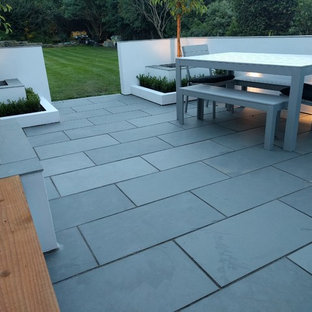 Ispirazione per un patio o portico contemporaneo di medie dimensioni e nel cortile laterale con pavimentazioni in pietra naturale