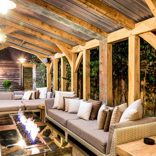 Design ideas for a large contemporary courtyard patio in Sussex with natural stone paving and a fire feature.
