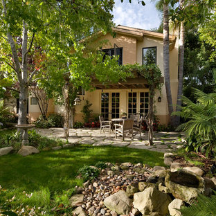 Ispirazione per un patio o portico boho chic dietro casa con fontane, pavimentazioni in cemento e una pergola