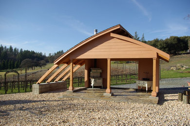 Imagen de patio de estilo de casa de campo de tamaño medio en patio trasero con adoquines de piedra natural