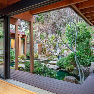 Foto di un grande patio o portico etnico dietro casa con fontane, pedane e un parasole
