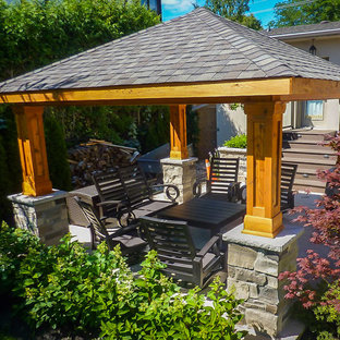 Idee per un piccolo patio o portico american style nel cortile laterale con pedane e un gazebo o capanno
