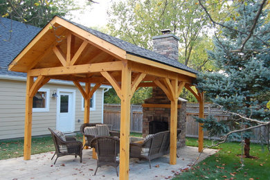 This is an example of a medium sized traditional back patio in Toronto with a fire feature, concrete paving and a gazebo.