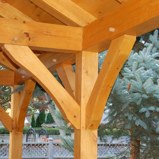 Immagine di un patio o portico american style di medie dimensioni e dietro casa con un focolare, pavimentazioni in cemento e un gazebo o capanno