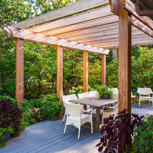 Ispirazione per un grande patio o portico stile marino dietro casa con un focolare, pedane e una pergola