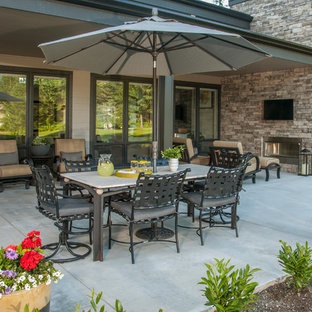 Inspiration for a mid-sized contemporary backyard concrete patio remodel in Seattle with a fire pit and a roof extension