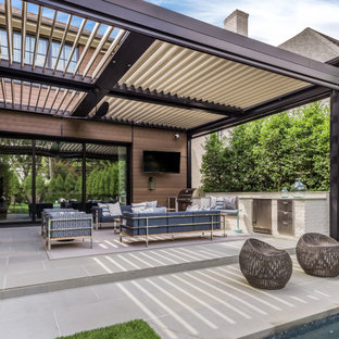 Ispirazione per un grande patio o portico tradizionale dietro casa con piastrelle e una pergola