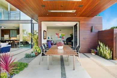 サンディエゴにある高級な広いミッドセンチュリースタイルのおしゃれな裏庭のテラス (アウトドアキッチン、コンクリート板舗装	、張り出し屋根) の写真