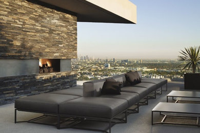 Inspiration for a large modern back patio in Los Angeles with a fire feature, concrete slabs and a roof extension.