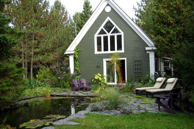 Diseño de patio rural de tamaño medio sin cubierta en patio trasero con fuente y adoquines de piedra natural