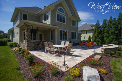 Foto de patio clásico renovado de tamaño medio en patio trasero y anexo de casas con brasero y adoquines de piedra natural