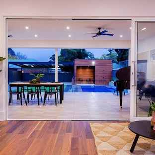 Idee per un grande patio o portico contemporaneo dietro casa con pavimentazioni in pietra naturale e un tetto a sbalzo