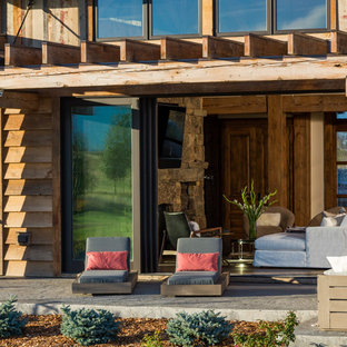 Ispirazione per un grande patio o portico rustico dietro casa con cemento stampato e una pergola