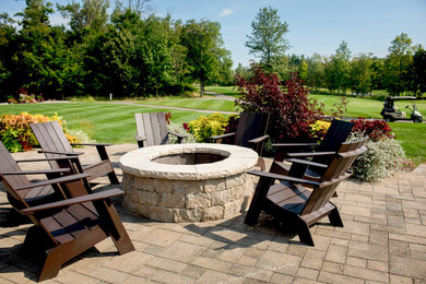 Example of a large classic backyard concrete paver patio design in Columbus with a fire pit