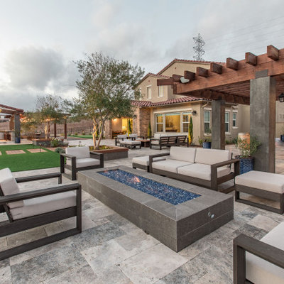 Large trendy backyard stone patio photo in San Diego with a fire pit and a pergola