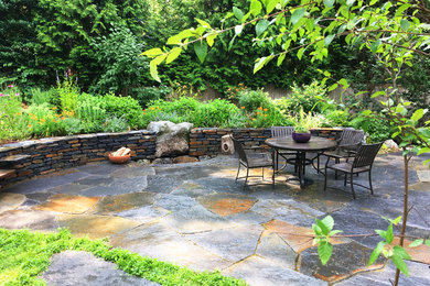 Example of a mid-sized mountain style backyard stone patio design in Boston with a fire pit