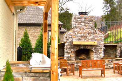 Mid-sized mountain style backyard stamped concrete patio photo in Nashville with a fireplace and a pergola