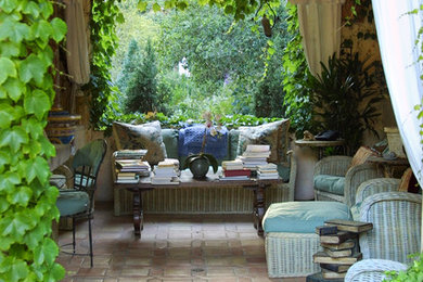 Patio - large french country backyard tile patio idea in Santa Barbara with a roof extension