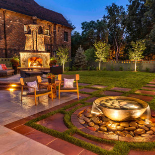Idee per un ampio patio o portico classico dietro casa con pavimentazioni in pietra naturale e una pergola