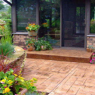 Ispirazione per un patio o portico tradizionale di medie dimensioni e dietro casa con cemento stampato e una pergola