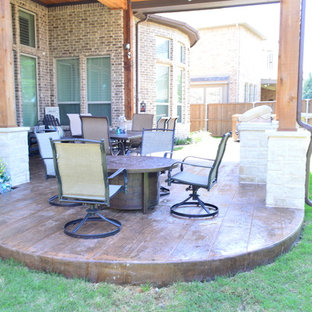 Foto di un grande patio o portico boho chic dietro casa con cemento stampato e un tetto a sbalzo