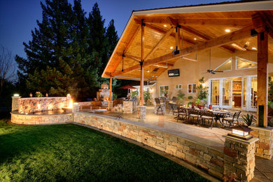 Идея дизайна: большой двор на заднем дворе в классическом стиле с местом для костра, покрытием из декоративного бетона и навесом
