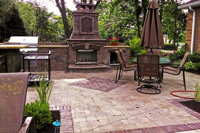 Inspiration for a mid-sized timeless backyard brick patio kitchen remodel with no cover
