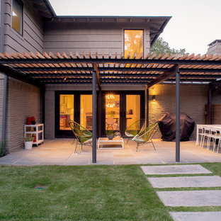 Foto di un patio o portico minimal di medie dimensioni e dietro casa con lastre di cemento e una pergola