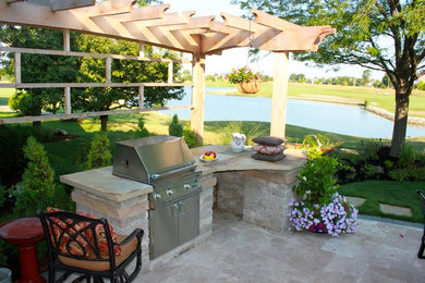 Patio kitchen - mid-sized transitional backyard stone patio kitchen idea in Indianapolis with a pergola