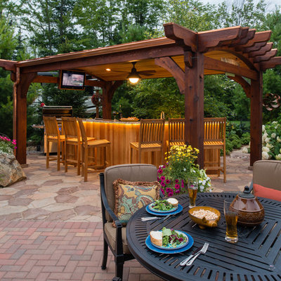 Example of a mid-sized classic backyard brick patio design in Other with a gazebo