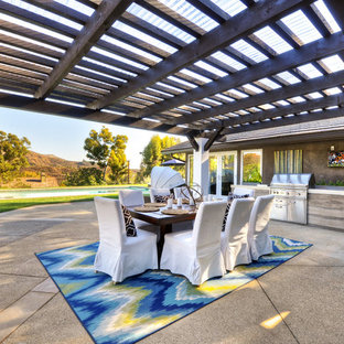 Aménagement d'une terrasse arrière classique avec un gravier de granite et une pergola.