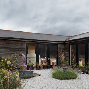 Esempio di un grande patio o portico nordico in cortile con un giardino in vaso, ghiaia e nessuna copertura
