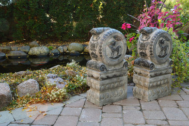 Inredning av en asiatisk mellanstor uteplats på baksidan av huset, med en fontän och naturstensplattor