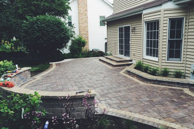 This is an example of a medium sized classic back patio in Chicago with brick paving.
