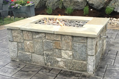 Example of a mid-sized backyard concrete paver patio design in Seattle with a fire pit