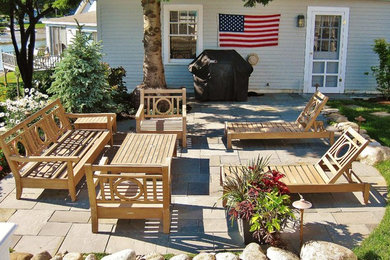 Example of a mid-sized beach style courtyard stone patio design in Portland Maine with no cover