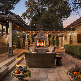 Foto di un patio o portico vittoriano di medie dimensioni e dietro casa con un focolare, pavimentazioni in pietra naturale e una pergola