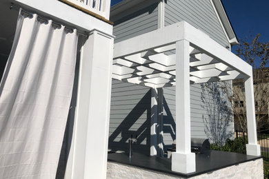 Idee per un patio o portico minimalista di medie dimensioni e dietro casa con piastrelle e una pergola