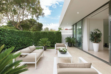 Cette image montre une terrasse design de taille moyenne avec une cour et des pavés en pierre naturelle.