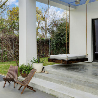 Example of a mid-sized southwest backyard concrete patio design in Houston with a roof extension