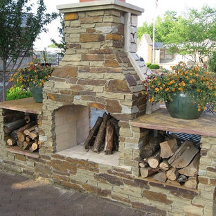 Ispirazione per un patio o portico tradizionale nel cortile laterale con un caminetto, pavimentazioni in mattoni e nessuna copertura