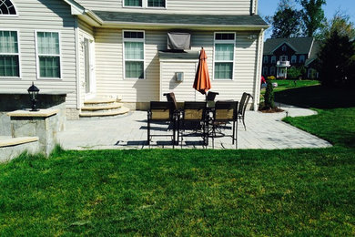 This is an example of a large classic back patio in DC Metro with an outdoor kitchen and concrete paving.